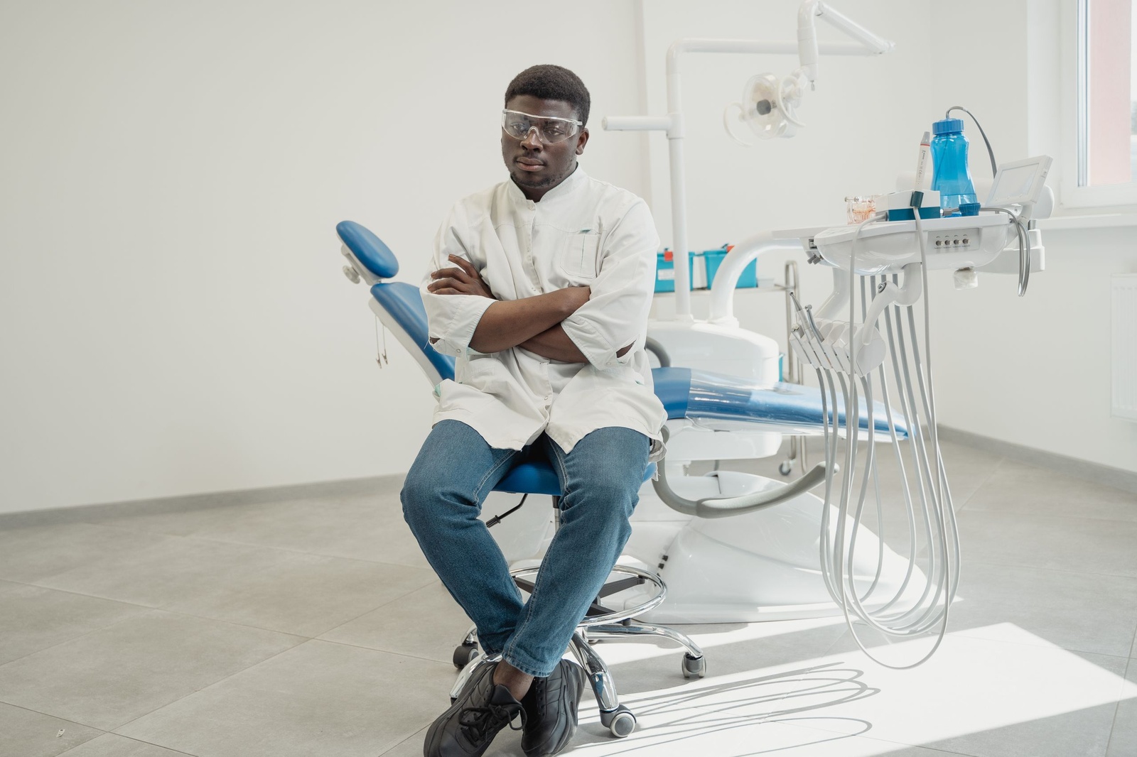 Dentist at Cadugo Dental Clinic beside the treatment chair